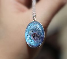 "If you are searching for a truly unique and breathtaking memorial gift, look no further than our milky way pendants! These cremation galaxy necklaces are handcrafted for you with the ashes you provide. Each swirling, shimmery galaxy is set in a 18x25mm oval sterling silver pendant and hangs from your choice of sterling silver chain. These galactic necklaces are built in layers to give them as much depth as possible. In the comments box, please note how defined you would like the \"swirl\" to be Celestial Style Necklace With Polished Finish As Gift, Handmade Silver Cosmic Jewelry, Handmade Cosmic Jewelry For Gifts, Handmade Cosmic Style Jewelry For Gifts, Cosmic Style Handmade Jewelry As A Gift, Fusion Style Polished Finish Necklaces For Gifts, Fusion Style Oval Pendant Necklace For Gift, Eclectic Oval Pendant Necklace For Gift, Thumbprint Jewelry