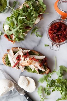 an open face sandwich with lettuce, tomato sauce and mozzarella on the side