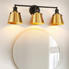 a bathroom with a round mirror and two lights