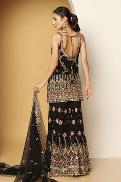 Black sleeveless padded short kurta in georgette base with all over mughal bloom art multi color thread, zari, mirror embroideries, sequin highlights and paan neckline. Paired with a floral motif embroidered sharara and mirror border embellished net dupatta. - Aza Fashions Traditional Sleeveless Palazzo Set For Eid, Sleeveless Embroidered Sharara For Eid, Embroidered Sleeveless Sharara For Eid, Fitted Sleeveless Sharara For Eid, Sleeveless Fitted Sets With Dupatta, Sleeveless Sharara With Zari Work For Eid, Sleeveless Sharara With Dupatta For Diwali, Sleeveless Sharara For Diwali Festive Occasion, Sleeveless Sharara For Diwali Festivities