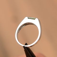 It is a green sapphire ring. The main stone is 5 mm*7 mm emerald cut.weight about 1.20 carats. The basic metal is sterling silver and plated with rhodium/14k white gold/14k rose gold/14k yellow gold You can also go to my shop Home for more elegant rings: https://www.etsy.com/shop/godjewelry?ref=hdr_shop_menu Customization is always welcome and please feel free to contact with me if you have any design ideas! Modern Emerald Cut May Birthstone Jewelry, Modern Asscher Cut Emerald Promise Ring, Minimalist Emerald Cut Green Jewelry, Modern Sterling Silver Emerald Cut Sapphire Ring, Modern Green Emerald-cut Jewelry, Modern Emerald Ring With Baguette Cut And Prong Setting, Modern Emerald Ring With Baguette Cut, Modern Baguette Cut Emerald Ring For May Birthstone, Modern White Gold Emerald Ring With Baguette Cut