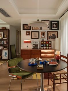 a dining room table with chairs and pictures on the wall