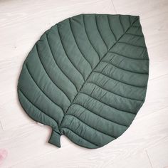 a large green leaf laying on top of a white floor