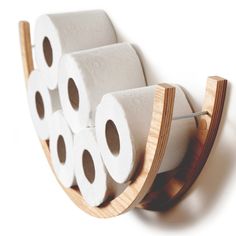 three rolls of toilet paper on a wooden holder