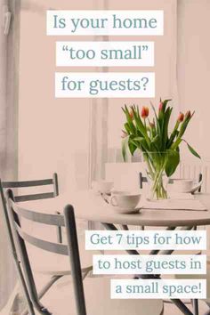 a table with two chairs and a vase filled with tulips on top of it