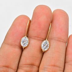 Moissanite Earrings (Pair) ✪Gemstone: Natural Moissanite ✪Metal: 18k solid Yellow gold. ✪Stone size: 6x8 mm. ✪Stone Shape : Oval ✪Stone Weight : 2.50 Ct. ✪ Earring Weight : 1.31 Gram ✪Earring Length : 25 mm. ✪Earring width : 7 mm. ✪Setting type: Bezel wire setting. If you need any other preferred stone please contact us. Benefits of Moissanite Gemstones Moissanites are crucial in physical healing. ... This gemstone is also known to improve communication between couples and close family members. ... Moissanite gemstones also enable the wearer to connect with their inner spirituality better.   QUALITY OF MATERIALS: Metal: Most of our jewelry at JewelryMansion is made with precious metals like gold and silver. These metals are 100% non-allergic to our skin. Gemstone: All of our jewelry is mad Oval Fine Jewelry Earrings With Bezel Setting, Ethical 14k Gold Oval Earrings, Bezel Wire, Close Family, Gold Earrings Wedding, Physical Healing, Bezel Earrings, Improve Communication, Solid Gold Earrings