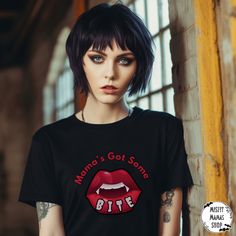 Unleash your inner goth and celebrate your love for the darkly whimsical with our Gothic Vamp Mama Tshirt - a timeless canvas for your alternative style and a commitment to sustainability. Crafted with meticulous attention to detail, this shirt is not just a fashion statement; it's a reflection of your unique expression.   Key Features:   🖤 Gothic Elegance: This ultra cotton tee boasts a classic fit and medium fabric weight (6.0 oz/yd²)--the perfect match for all-season wear. Made from 100% US Black Emo T-shirt For Halloween, Edgy Halloween T-shirt For Alternative Fashion, Gothic Black T-shirt For Halloween, Edgy Black T-shirt For Party, Edgy Party T-shirt With Graphic Print, Edgy Graphic Print T-shirt For Party, Emo Halloween T-shirt With Short Sleeves, Edgy Halloween Concert T-shirt, Alternative Halloween T-shirt With Letter Print