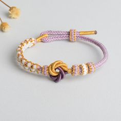 Description: The Mandala Peach Blossom Knot Bracelet is a handcrafted masterpiece, woven with precision and love. This bracelet offers a delicate yet durable design with a 3mm thickness and an adjustable perimeter of 18cm, making it perfect for any wrist size. The mandala-inspired knot and peach blossom elements symbolize beauty, harmony, and balance. Ideal for daily wear or as a thoughtful gift, this bracelet is more than just an accessory – it's a statement of elegance. Handwoven craftsmanship Pink Adjustable Spiritual Braided Bracelet, Adjustable Woven Bangle Bracelet, White Braided Beaded Bracelets As Gift, Adjustable Woven Jewelry, Adjustable Woven Braided Bracelet With Round Beads, Adjustable Braided Bracelet With Round Beads, Pink Braided Friendship Bracelets Gift, Pink Braided Friendship Bracelet Gift, Traditional Adjustable Purple Bracelets