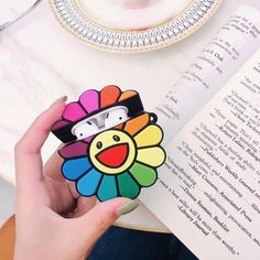 a person holding an iphone case with a colorful flower on the front and back cover