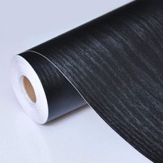 a roll of black woodgrain paper sitting on top of a table