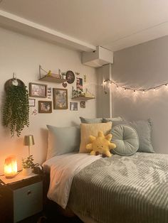 a bed room with a neatly made bed and lots of pictures on the wall above it