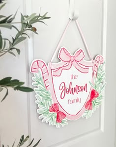 a christmas ornament hanging on a door with holly wreath and candy canes