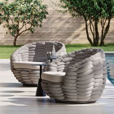 two chairs sitting next to each other near a pool