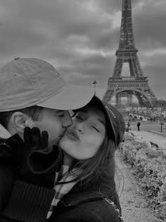 a man and woman kissing in front of the eiffel tower, paris france