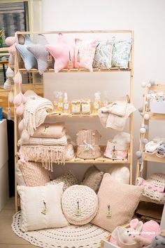 a room filled with lots of different types of pillows and blankets on top of wooden shelves