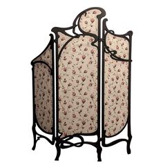 an ornate iron and fabric screen with roses on it, set against a white background