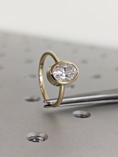 a diamond ring sitting on top of a metal surface