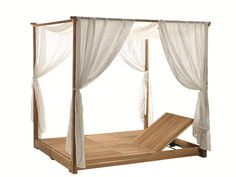 a wooden bed with white drapes on it