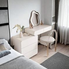 a bedroom with a bed, dresser and mirror in it's corner area next to a window