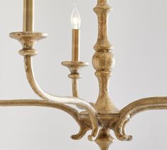 an antique chandelier with three candles lit