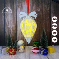 an ornament is shown next to presents and christmas tree ornaments on a table