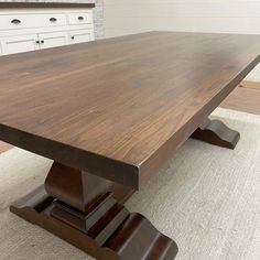 a large wooden table sitting on top of a rug