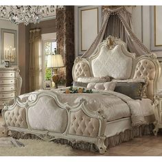 an ornate bedroom with white furniture and chandelier