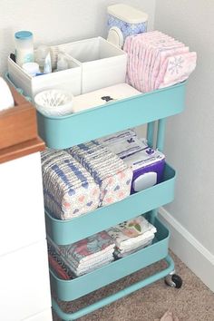 a blue cart filled with lots of diapers next to a bathroom sink and toilet