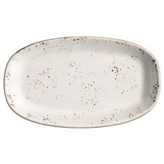 an oval white plate with black speckles on the rim and bottom, against a white background