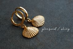 "Gold plated earrings with shell pendants. You can choose from two different earhooks (see picture number 2): 1: 12 mm hooks 2: 16 mm Creoles Also you can choose the style of the shell-charms: matt shiny M A T E R I A L gold-plated brass S I Z E Shiny gold plated Creoles: 0.6 inch / 16 mm in diameter Shiny gold plated Leverbacks: 12 mm in diameter Matt or shiny gold plated Shell pendants: 10 x 12 mm ------------------------------------------------------------------------------------------------- Shell-shaped Yellow Gold Earrings Gift, Gold Shell With Matching Earrings Gift, Shell-shaped Yellow Gold Earrings For Gifts, Yellow Gold Shell-shaped Earrings Gift, Nickel-free Shell-shaped Earrings Gift, Adjustable Shell Earrings For Gifts, Gold Shell Ear Wire Gift, Gold Shell Earrings With Ear Wire For Gift, Gold Shell Earrings With Ear Wire As Gift