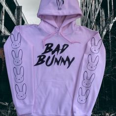 Brand New (Nwot) Bad Bunny Hoodie (Light Pink) With Bad Bunny On The Front, Bunny Ears On The Hood And Bunnies Down The Sleeves (Black). Trendy Hoodie With Ribbed Cuffs, Urban Pink Long Sleeve Tops, Pink Long Sleeve Urban Tops, Trendy Pink Sweatshirt For Winter, Trendy Pink Winter Sweatshirt, Pink Hoodie For Streetwear, Trendy Pink Sweatshirt With Ribbed Cuffs, Pink Hoodie Top For Streetwear, Trendy Pink Cotton Sweatshirt