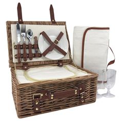 a wicker picnic basket with utensils and napkins