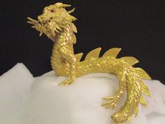 a gold dragon figurine sitting on top of snow