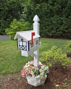 a white mailbox with red, white and blue painted on it in a flower pot