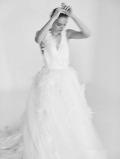 black and white photograph of a woman in a wedding dress with her hands on her head