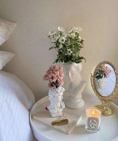 a white table with flowers and a mirror on it