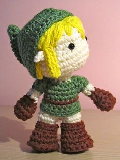 a small crocheted toy with a hat and gloves on it's head