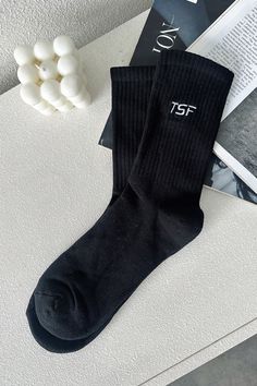 Millie Socks are designed to provide optimal comfort and style. They offer mid-calf coverage and ribbed ankles that add an extra touch of style. The iconic TSF logo is featured prominently to provide a chic look to any outfit. Black Casual Socks For Spring, Casual Black Socks For Spring, Trendy Black Socks For Winter, Trendy Black Winter Socks, Casual Black Mid-calf Socks, Black Socks For Fall Streetwear, Black Stretch Socks For Streetwear, Black Fall Streetwear Socks, Casual Black Socks For Fall