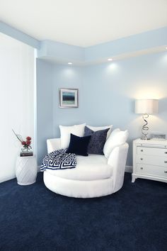 a living room with blue carpet and white furniture