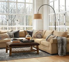 a living room filled with furniture and large windows