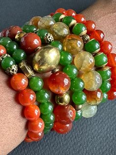 a close up of a person's arm wearing bracelets with beads on it