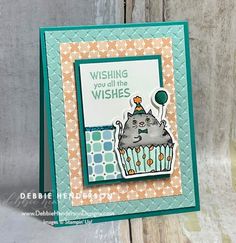 a close up of a card with a cat on top of a cupcake and the words wishing you all the wishes