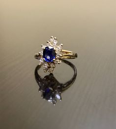 DeKara Designs Clearance Metal- 14K Yellow Gold, .583. Stones- 1 Oval Ceylon Blue Sapphire 0.80 Carats, 4 Marquise Diamonds G Color VS1 Clarity 0.40 Carats, 8 Round Diamonds H Color VS1 Clarity 0.20 Carats. Size- Ring is a 6 3/4, and could be sized up or down at no additional cost! FREE SIZING Handmade 14K Yellow Gold Ceylon Blue Sapphire Halo Diamond Ring. This ring is inspired by the Art Deco era with an enticing fiery oval shaped Ceylon Blue Sapphire. The sapphire is set in between 4 prongs. Blue Diamond Cluster Ring With Prong Setting, Blue Cluster Ring With Prong Setting For Anniversary, Blue Cluster Sapphire Ring For Wedding, Heirloom Blue Sapphire Cluster Ring, Luxury Blue Marquise Cut Ring, Blue Cluster Rings With Accent Stones, Heirloom Blue Cluster Ring With Prong Setting, Heirloom Blue Sapphire Ring Hallmarked, Heirloom Blue Cluster Ring With Center Stone