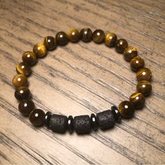 Men’s Tigers Eye Beaded Bracelet With Natural Lava Barrel Beads And Hematite Spacers. This Measures Size 8”. If You Like This But Need A Different Size, Please Feel Free To Drop A Comment Below. Thanks For Stopping By. Casual Brown Beaded Bracelets With Gemstone Beads, Casual Brown Beaded Bracelets With Gemstones, Casual Brown Bracelet With Black Beads, Casual Brown Bracelets With Black Beads, Casual Brown Bracelets With Gemstone Beads, Casual Brown Gemstone Beads Bracelets, Casual Brown Stretch Bracelet With Natural Stones, Tiger Eye Bracelet, Tigers Eye Gemstone