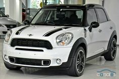 a white mini countryman parked in a showroom