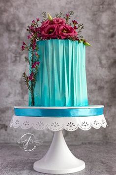 a blue cake with pink flowers on top