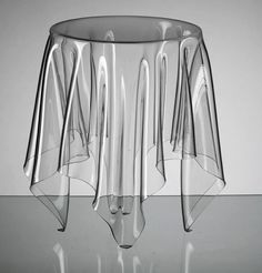 a clear glass vase sitting on top of a reflective surface with lines drawn across it