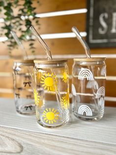 three glass cups with straws in them sitting on a table