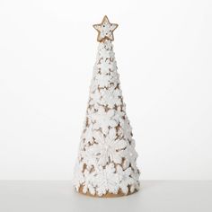 a small white christmas tree with snowflakes on it's sides and a star decoration on top