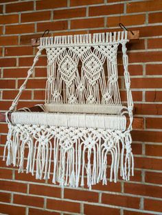 a white macrame hanging on a brick wall